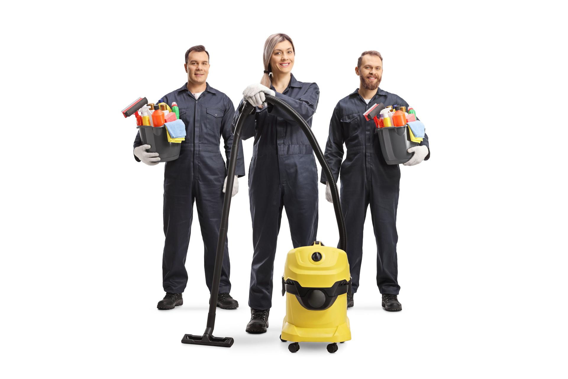 Team of professional cleaners in uniforms with a vacuum cleaner and cleaning supplies